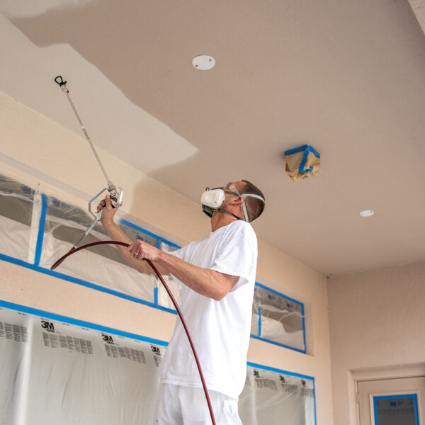 Titan Impact 400 XTRA using Titan RX-80 with extension pole spraying a ceiling with white paint